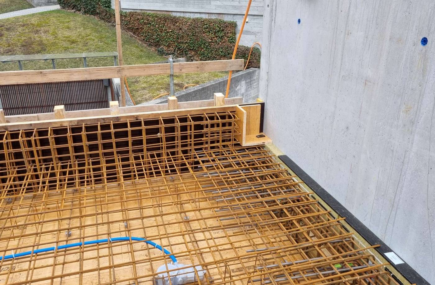 Neubau Aufbahrungshalle Friedhof Domat/Ems, Die Grünenfelder und Partner AG zeigt sich verantwortlich für die Projektierung, Ausschreibung und Ausführung des Massivbaus.